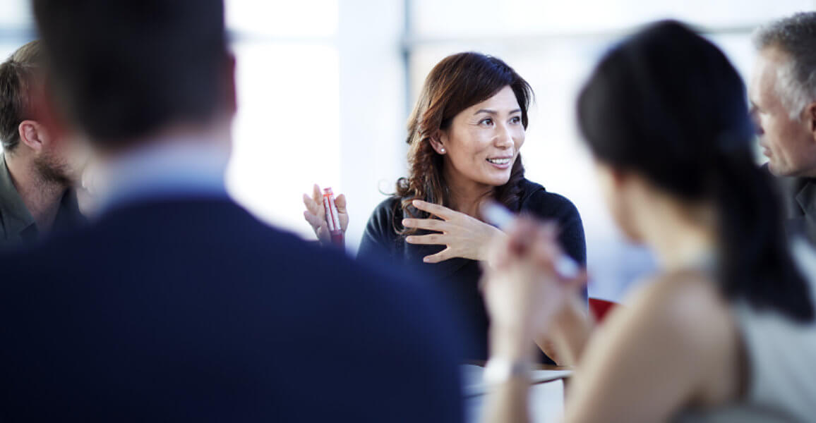 Smiling business people around a table for a strategic governance business meeting